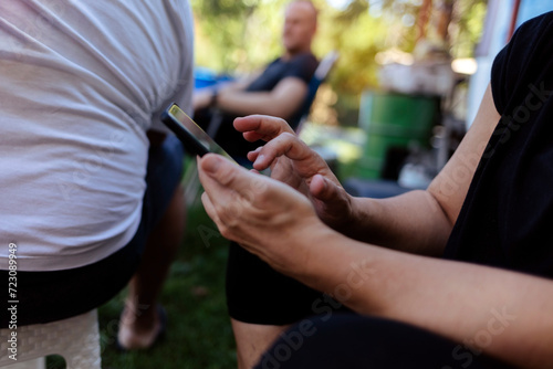 Photo of a hands and closeup of woman on a phone networking on social media, mobile app or the internet. Technology, nature and female person typing a text message on cellphone in the countryside.