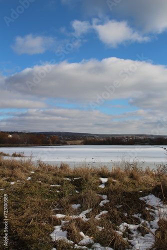 A body of water with grass and rocks and trees on the side