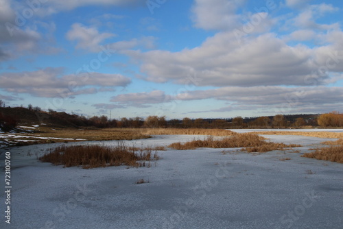 A frozen lake with trees in the background