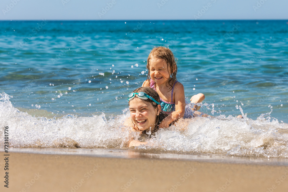 Joyful children playing in the shallow beach waves Joyful children playing in the shallow beach waves