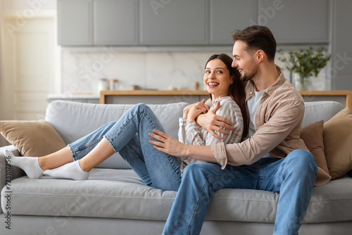 Couple embracing on couch with joyful expressions