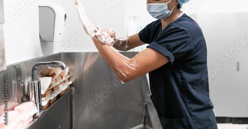 Surgeon having her hands surgically washed. A Caucasian doctor dressed in his right-hand profile with her hands full of foam and dressed in her surgical uniform. 