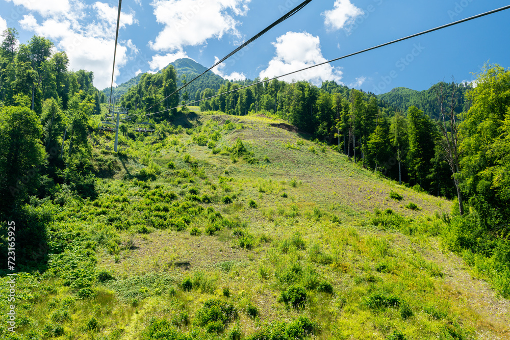 Cable car seats soar over beautiful mountains on a sunny day in Krasnaya Polyana Cable car seats soar over beautiful mountains on a sunny day in Krasnaya Polyana