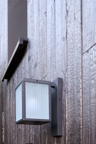 Obraz na płótnie Modern external lamp on burned wood wall w salonie