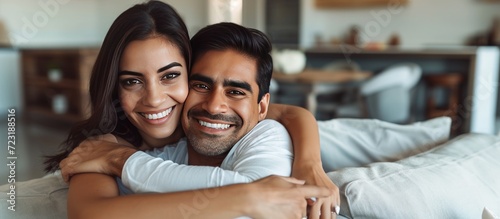 Happy couple mid adult indian man hug her latin woman at living room. AI generated image photo
