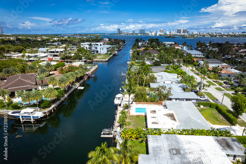 North Miami, Florida, USA - Aug 12, 2023: Aerial view of luxurious houses along a canal in Keystone Islands, with lush greenery and boats. photo