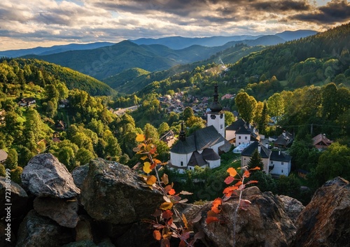 Village Spania Dolina. Fall in Slovakia. Old mining village. Historic church in Spania dolina. Autumn colored trees at sunset.