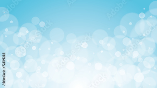 Shiny bokeh particles glittering on light blue background