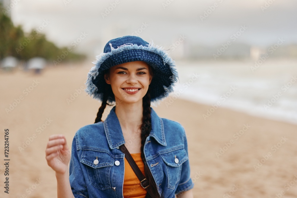 Happy Young Female Enjoying Summer Vacation on the Beach, Attractive Lady in Fashionable Hat and Bikini, Smiling with Blue Ocean and Sunny Sky as Background Happy Young Female Enjoying Summer Vacation on the Beach, Attractive Lady in Fashionable Hat and Bikini, Smiling with Blue Ocean and Sunny Sky as Background