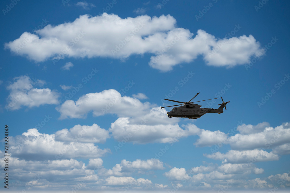 Fototapeta premium military helicopter flying in blue sky. High quality photo