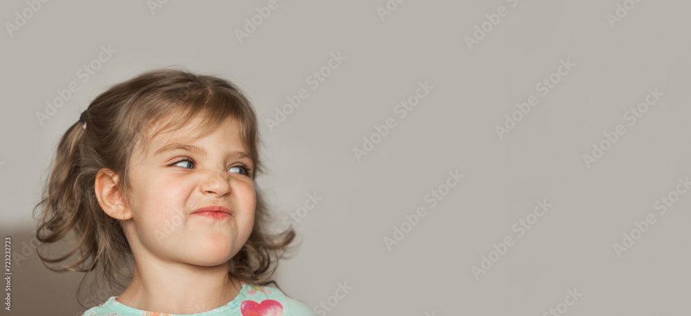 banner portrait of cheerful funny girl with cranky face looking to right on gray background banner portrait of cheerful funny girl with cranky face looking to right on gray background