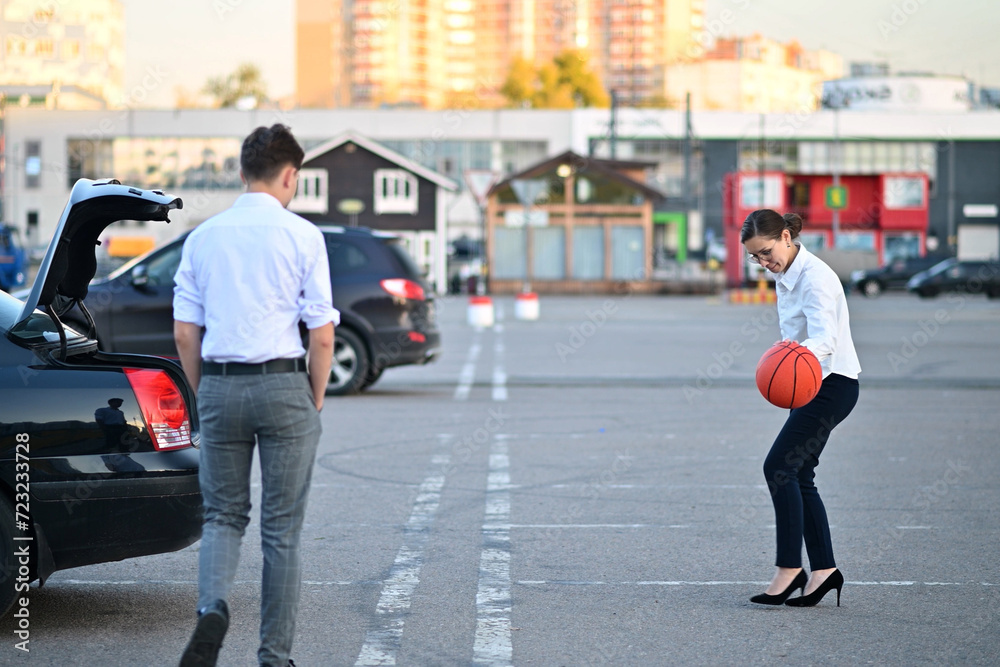 Young office workers or students playing basketball in a supermarket parking lot