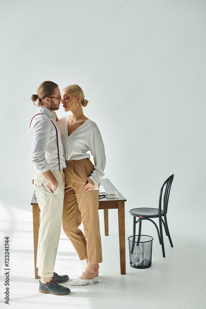 appealing couple in chic attires posing lovingly and preparing to kiss while at office, work affair appealing couple in chic attires posing lovingly and preparing to kiss while at office, work affair
