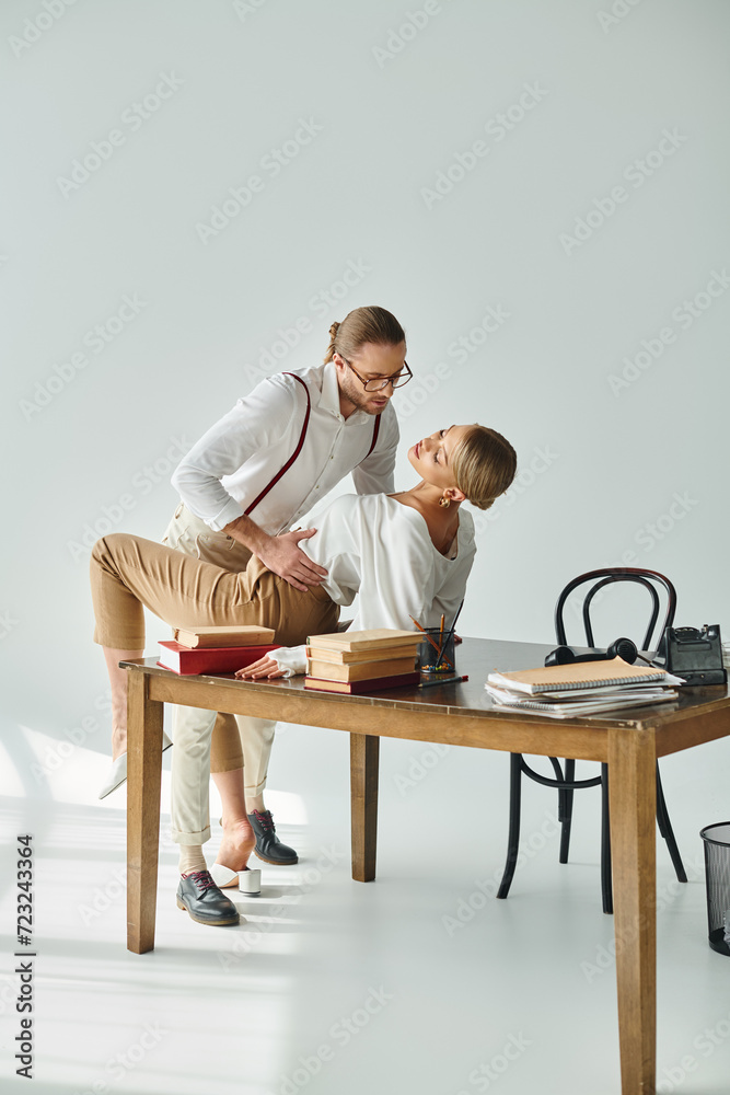 handsome bearded man with dapper style hugging and kissing his hot secretary on table, sexy couple