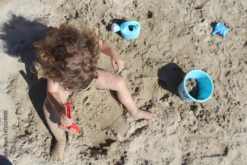 Bambino che gioca in spiaggia al mare in vacanza photo