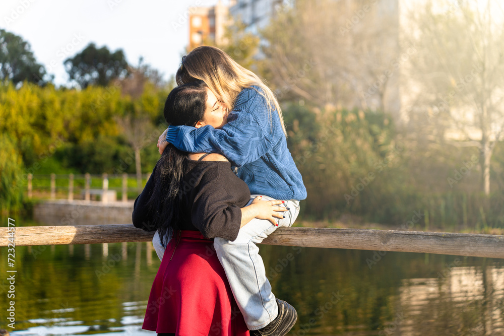 LGBT Lesbian couple hugging in the park showing their love LGBT Lesbian couple hugging in the park showing their love