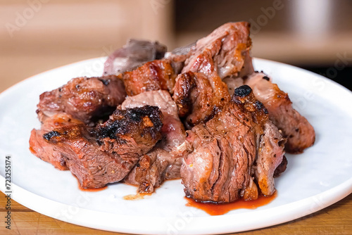 Beef grilled meat shish kebab on white plate. Homemade roasted sliced beef, serving food for restaurant, menu, advert or package, close up, selective focus