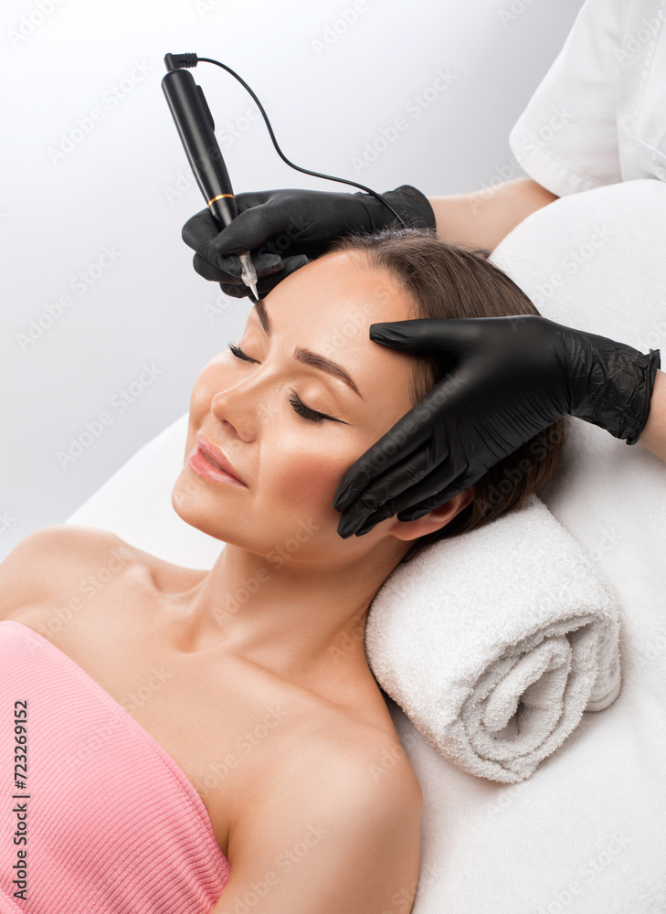 Permanent make-up for eyebrows of beautiful woman in beauty salon. Closeup beautician doing eyebrows tattooing. arrows on the eyes