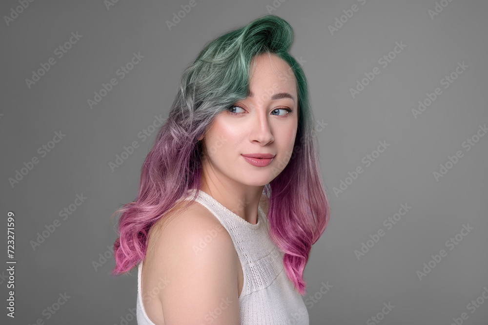 Trendy hairstyle. Young woman with colorful dyed hair on grey background Trendy hairstyle. Young woman with colorful dyed hair on grey background
