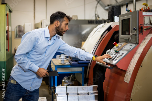 The engineer supervises the production of electrical devices in the factory.