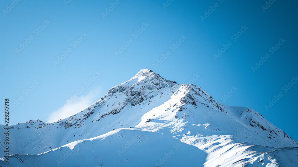 A snowy mountain peak under a clear blue sky.