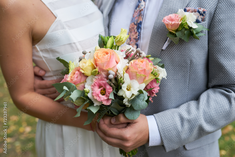 Tender hands cradle a bridal bouquet Tender hands cradle a bridal bouquet