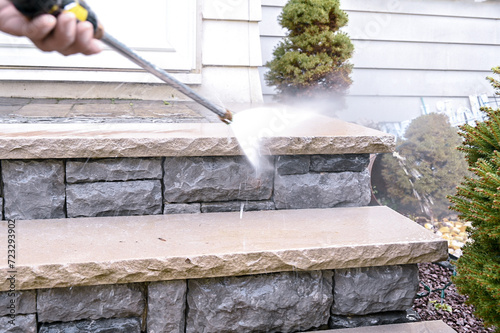 Close up of high pressure water jet during cleaning outdoor porch stairs.