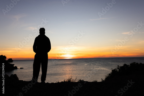 Person at sunrise at sea taking pictures