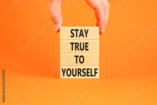 Stay true to yourself symbol. Concept word Stay true to yourself on beautiful wooden block. Beautiful orange table background. Businessman hand. Business stay true to yourself concept. Copy space