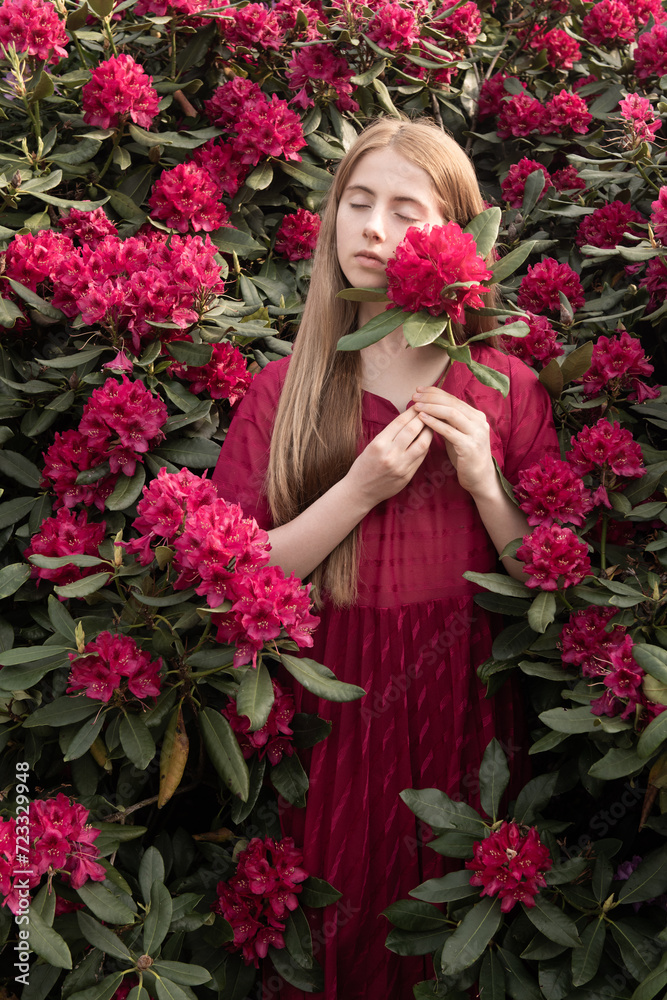 portrait of blonde girl in pink dress holding rhododendron flowers in spring portrait of blonde girl in pink dress holding rhododendron flowers in spring