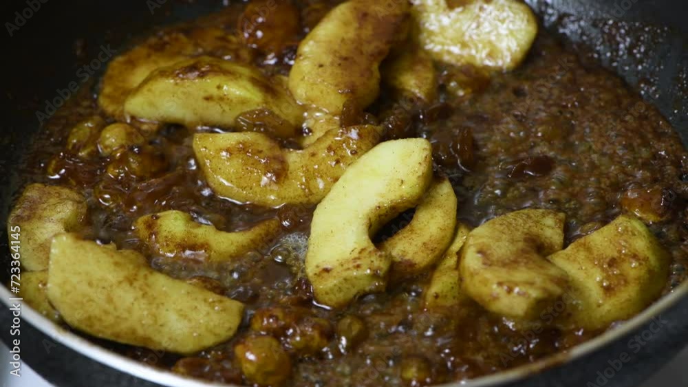 Add lemon juice, fried pieces of apples and raisins in butter-caramel sauce, stir. One of part of a series of video recipes. Real time, close-up. French apple pancake recipe Add lemon juice, fried pieces of apples and raisins in butter-caramel sauce, stir. One of part of a series of video recipes. Real time, close-up. French apple pancake recipe