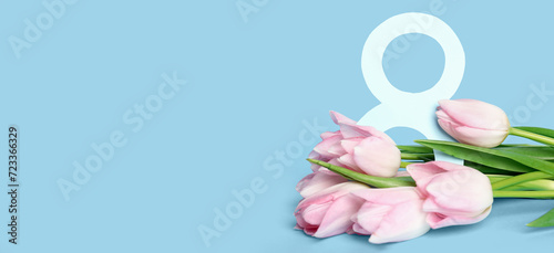 Beautiful bouquet of tulips and figure 8 on light blue background with space for text. International Women's Day celebration