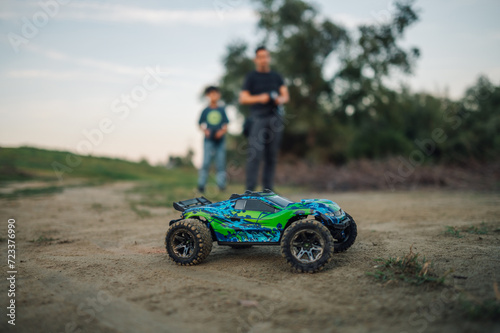 Selective focus on a monster car with father and son in a blurry background.