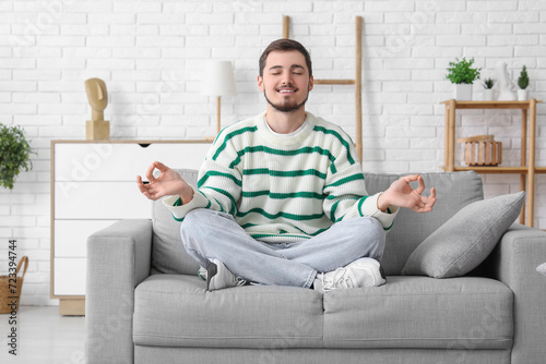 Handsome young man meditati...