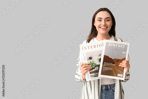 Young woman with magazines on light background photo