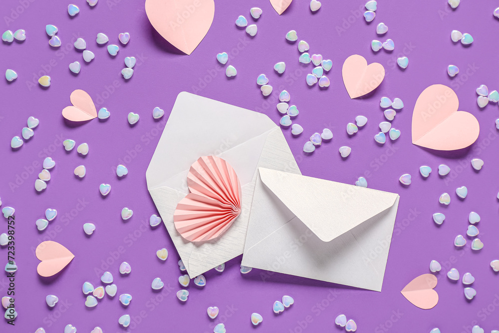 Composition with envelopes, paper hearts and glass stones on purple background. Valentine's Day celebration