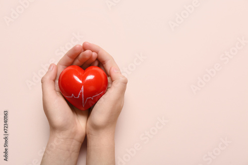 Fototapeta Naklejka Na Ścianę i Meble -  Female hands with red heart on pink background