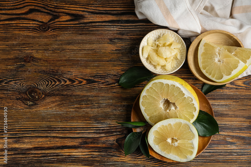 Plate and bowls with fresh pomelo fruits on wooden background Plate and bowls with fresh pomelo fruits on wooden background