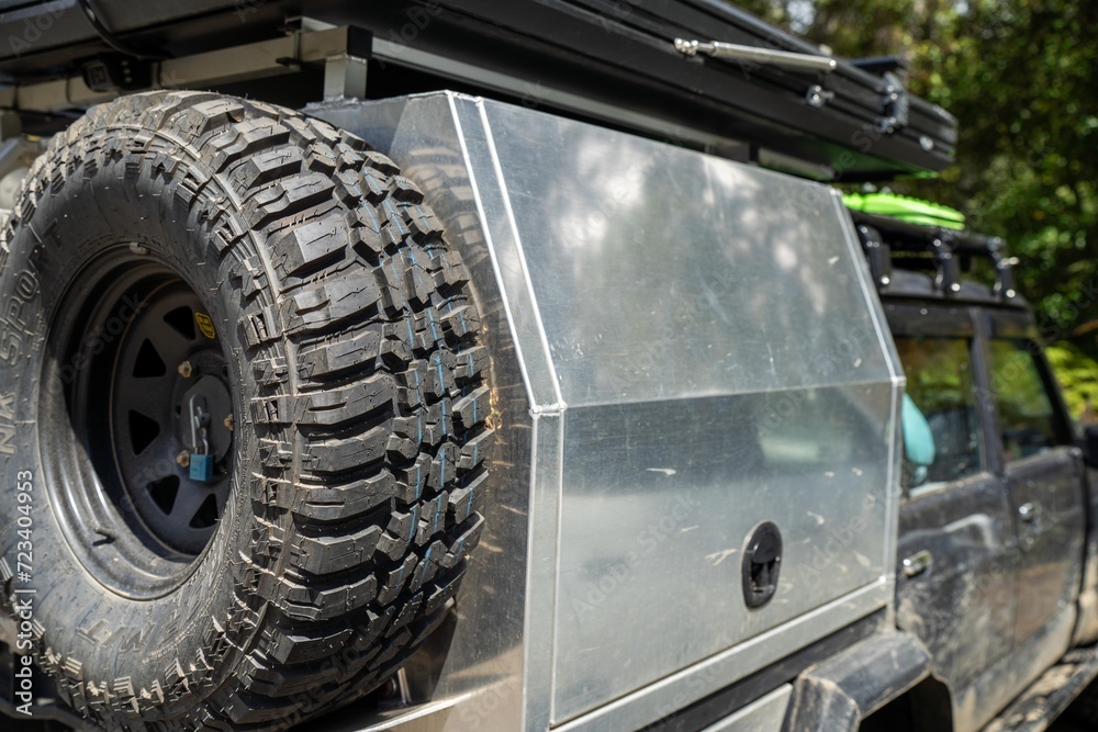 Camper trailer connected to a white car. SUV pulling a camper trailer with safety chains and wiring corrector