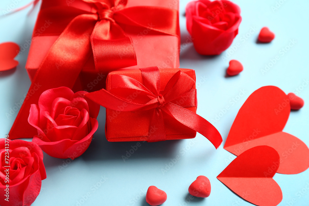 Gift boxes with red roses and paper hearts on blue background. Valentine's Day celebration Gift boxes with red roses and paper hearts on blue background. Valentine's Day celebration