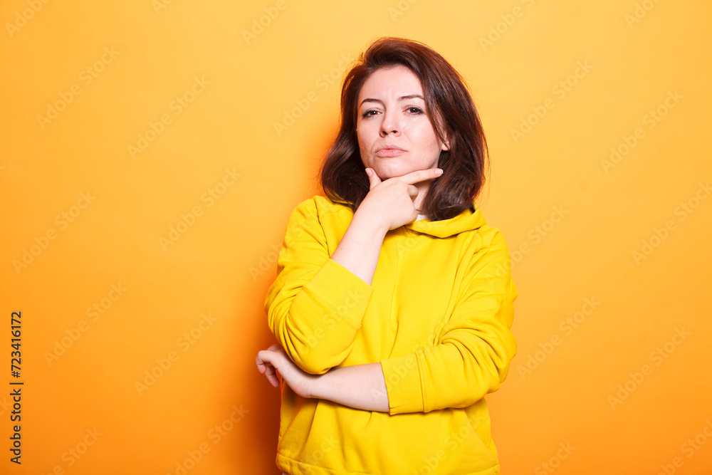 Caucasian woman with questioning thoughts and a vivid imagination. Contemplative person pondering an idea with hand on chin and pensive facial expression on camera. Caucasian woman with questioning thoughts and a vivid imagination. Contemplative person pondering an idea with hand on chin and pensive facial expression on camera.