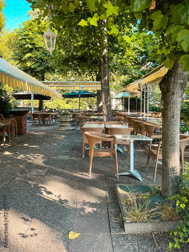 Shaded Outdoor Sidewalk Cafe in Summer. Green trees provide shade for this beautiful and relaxing sidewalk cafe in Strasbourg, France. A UNESCO World Heritage Site.