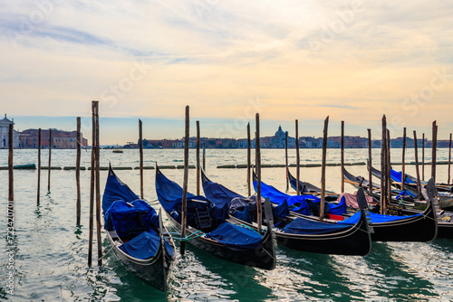 Traditional Gondolas moored on the pier in the Grand Canal in Venice, Italy © olyasolodenko