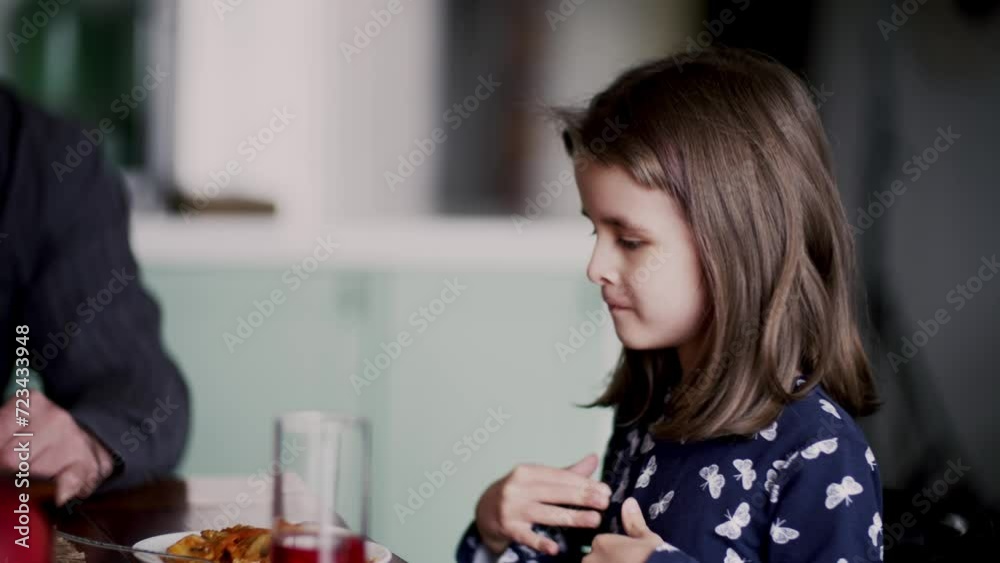 A cute schoolgirl talking about her adventures in school. Dining time with family. Concept of happy family relationships. Parents asking a funny daughter about days in school A cute schoolgirl talking about her adventures in school. Dining time with family. Concept of happy family relationships. Parents asking a funny daughter about days in school