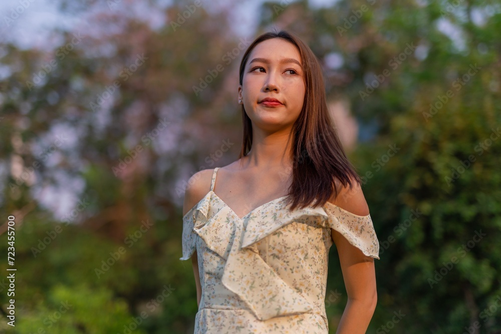 Beautiful young asian woman enjoying nature and sunset breeze at a park