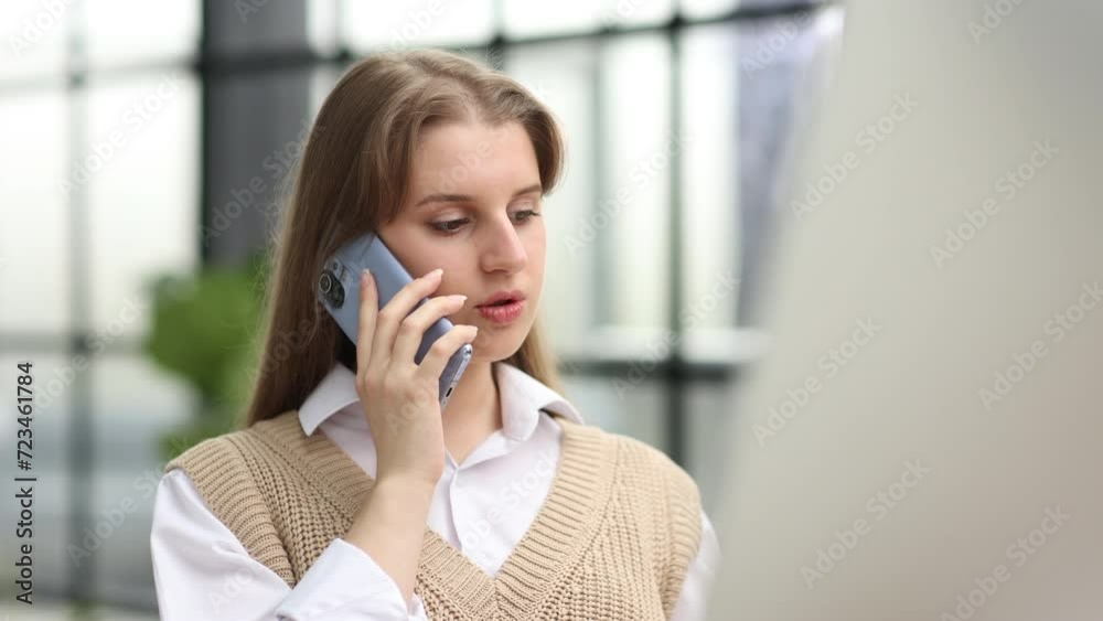 serious young woman talking on smartphone in the office. serious young woman talking on smartphone in the office.