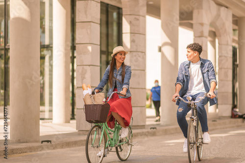 Couple riding on bicycles and having fun - Tourists driving around the city - Two friends riding bikes in downtown Guatemala.