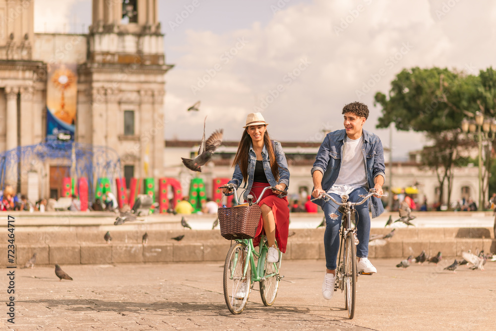 Portrait of young Latin couple with bikes in a downtown park.