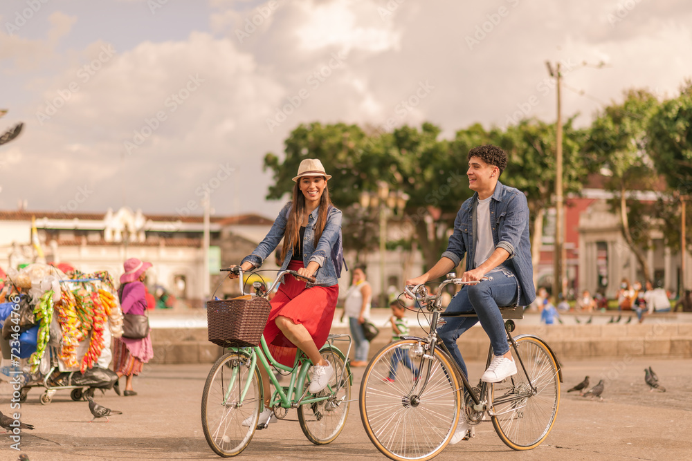 Obraz premium Portrait of a beautiful young Latin couple riding bicycles in the park of Guatemala City.