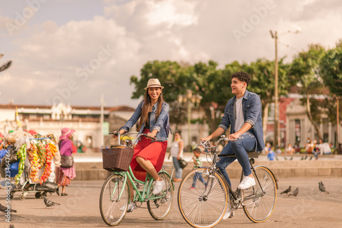 Portrait of a beautiful young Latin couple riding bicycles in the park of Guatemala City.